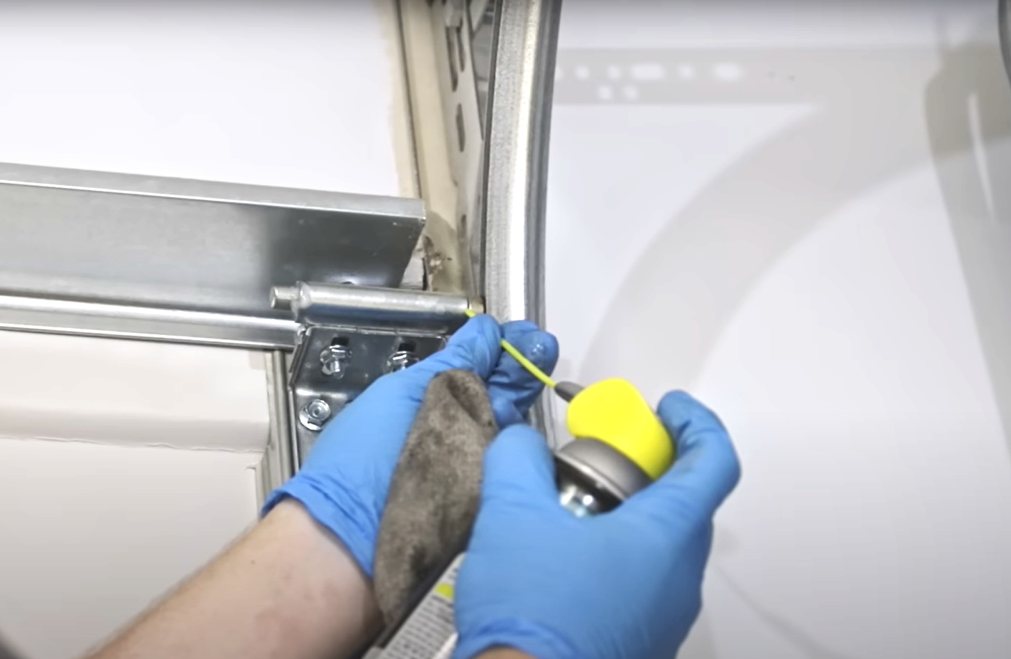 Professional technician repairing a garage door to fix a noisy component, demonstrating expert garage door fix solutions.