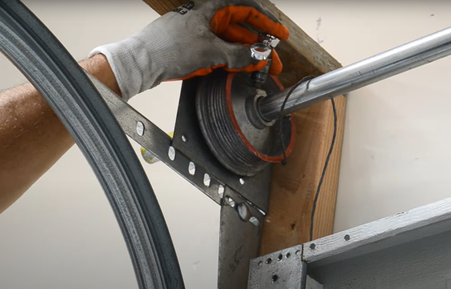 Technician performing garage door cable repair on a residential garage door, ensuring smooth operation and safety.