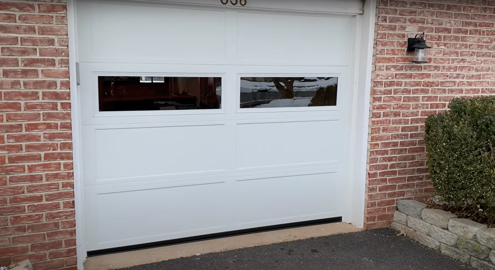 Before-and-after image of a garage door replacement showing an old, worn-out door on the left and a sleek, modern door on the right, highlighting improved aesthetics and functionality